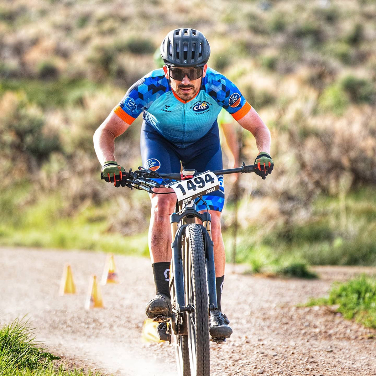 Steven racing a mountain bike in a Challenged Athletes Foundation jersey